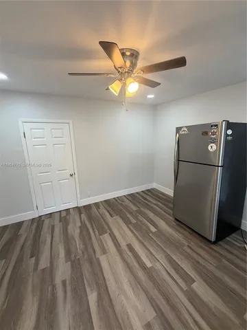 a view of empty room with wooden floor and ceiling fan