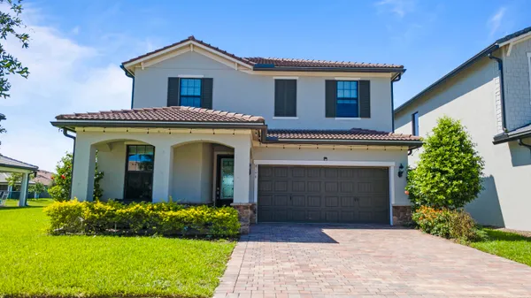 a front view of a house with a garden and plants