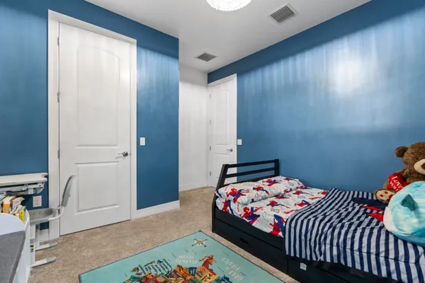 a bedroom with a large bed and a chandelier
