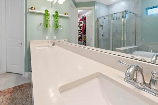 a spacious bathroom with a shower sink and mirror