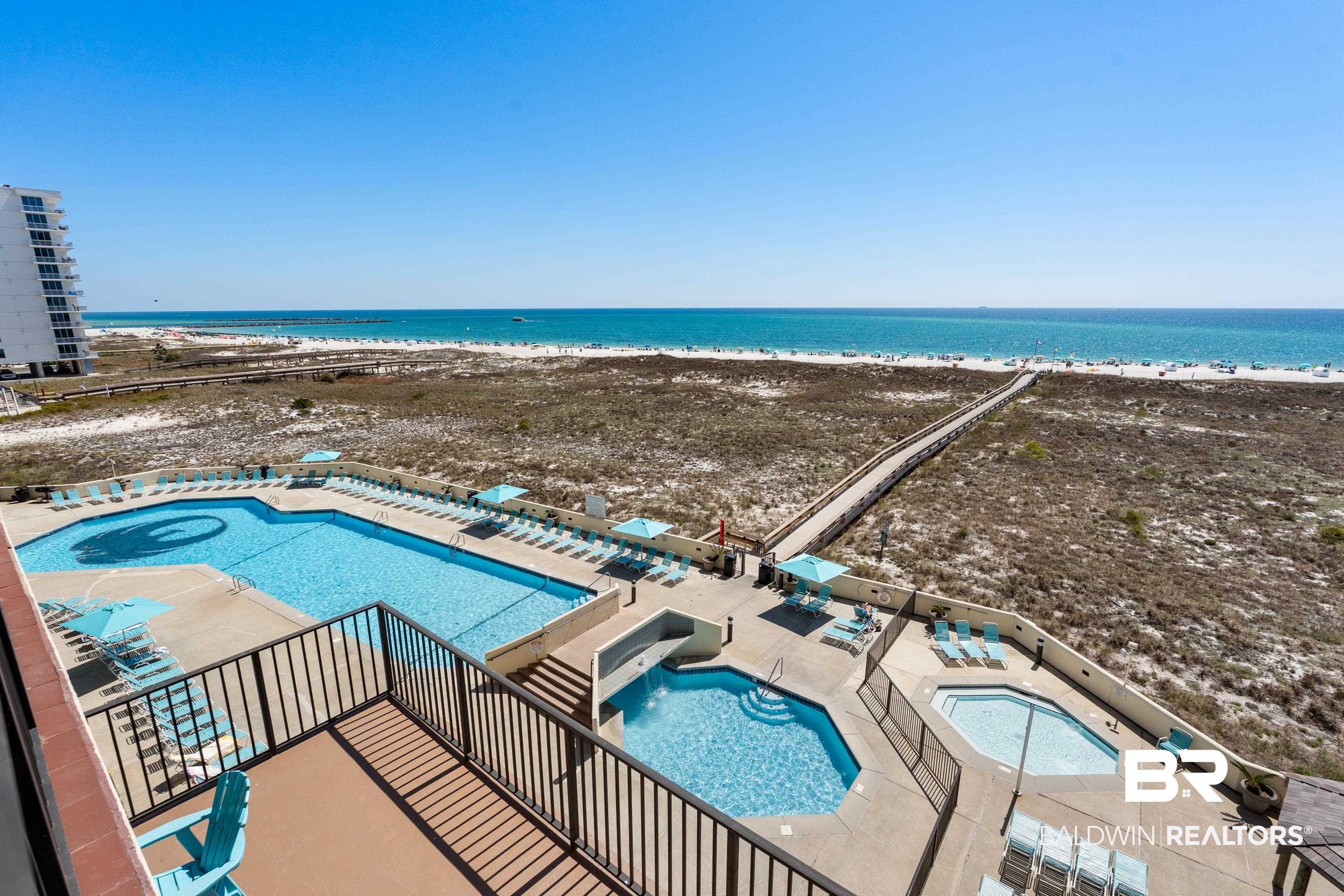 26802 Perdido Beach Boulevard, Unit 406 Orange Beach, AL 36561 - Photo 19 of 37 Community pool with a community hot tub, a patio area, and view of water and beach