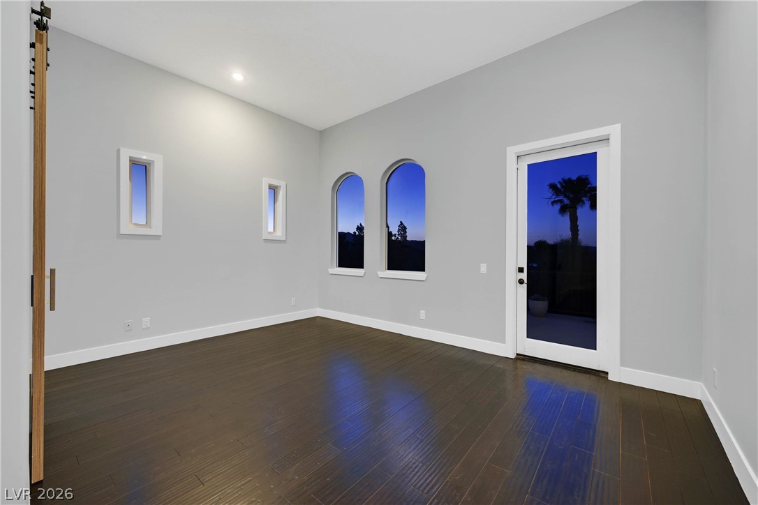 6 Rue Du Ville Henderson, NV 89011 - Photo 67 of 99 This luminous room features dark wood flooring, a sliding barn door, and arched windows with exterior access.