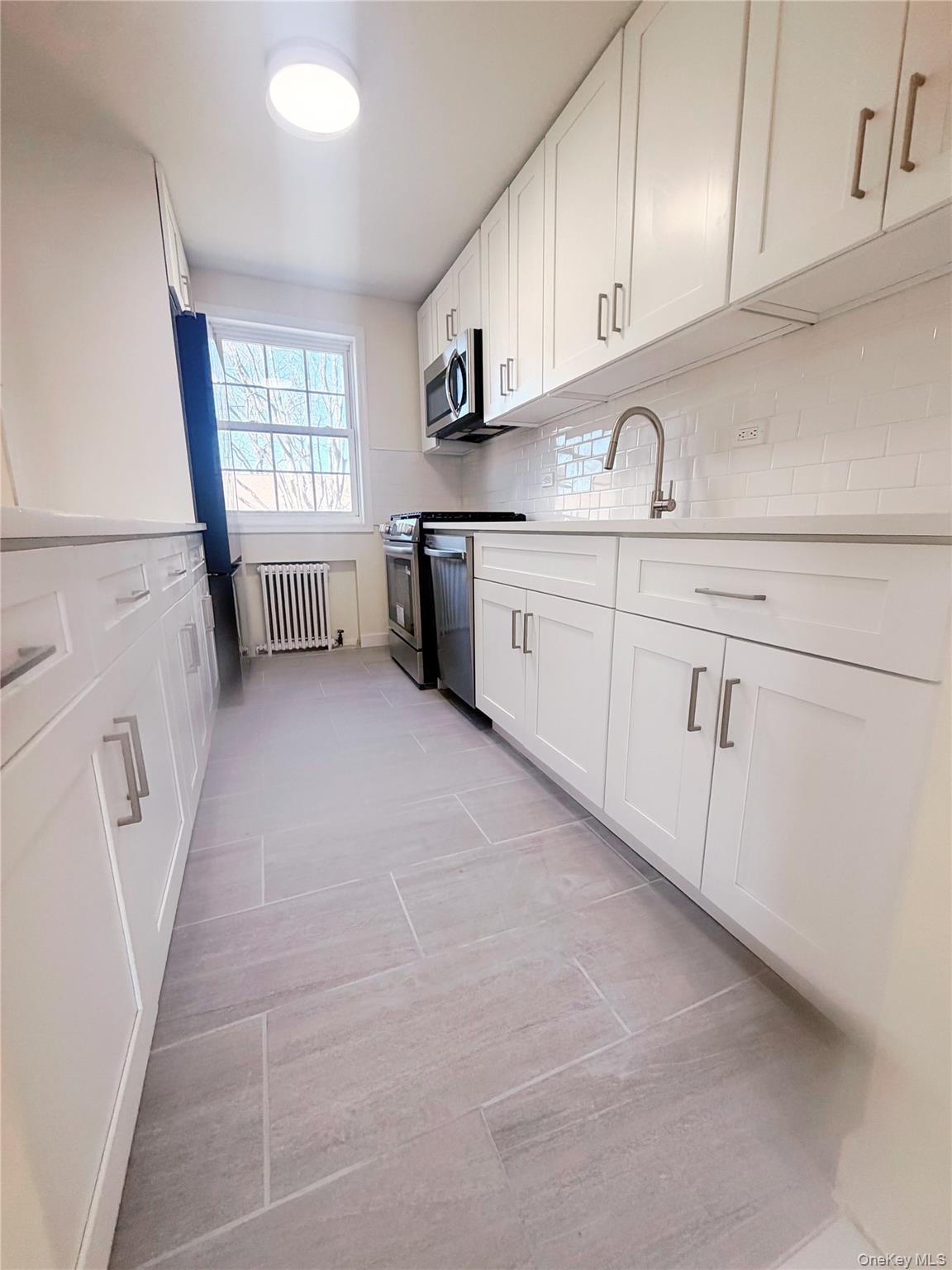 64-11 Springfield Boulevard, Unit B Queens, NY 11364 - Photo 2 of 11 a kitchen with cabinets and window