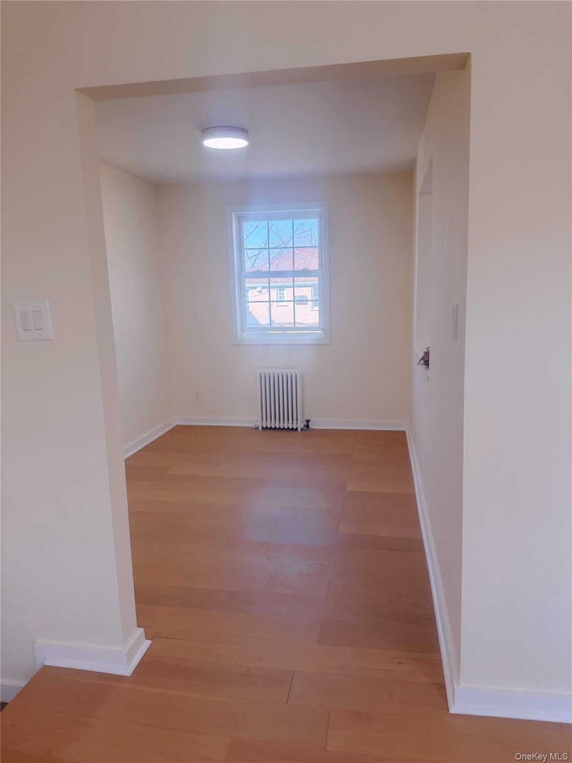 64-11 Springfield Boulevard, Unit B Queens, NY 11364 - Photo 3 of 11 an empty room with a window
