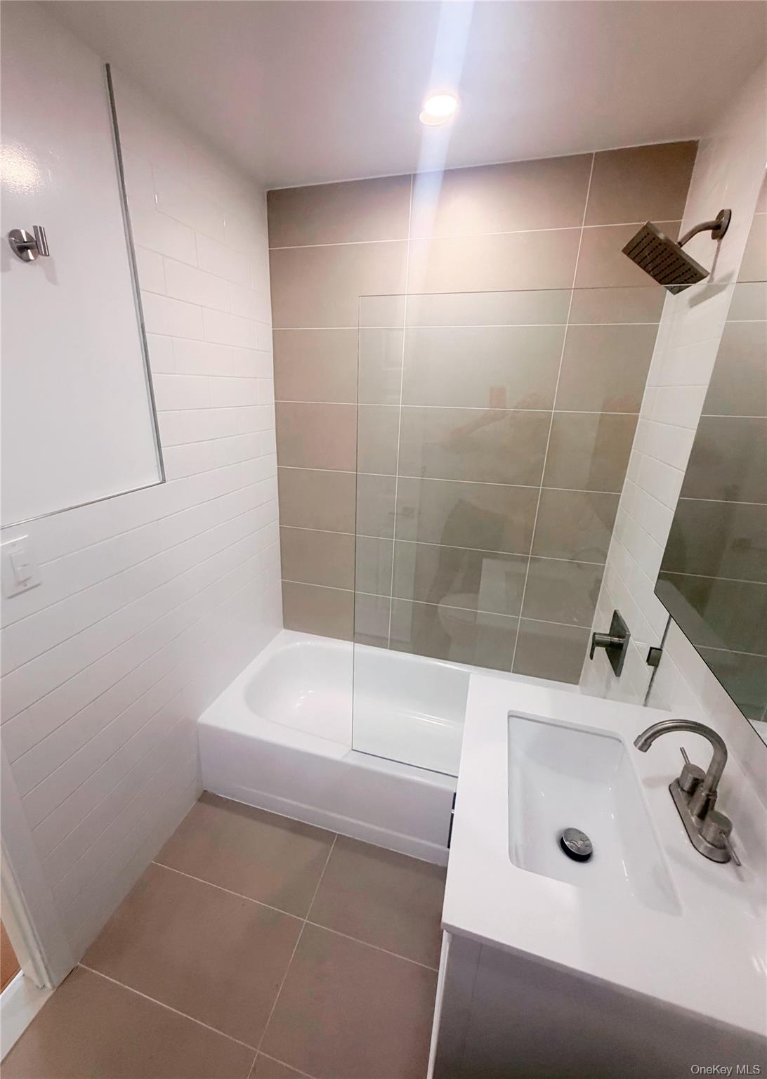 64-11 Springfield Boulevard, Unit B Queens, NY 11364 - Photo 6 of 11 a bathroom with a tub and a sink