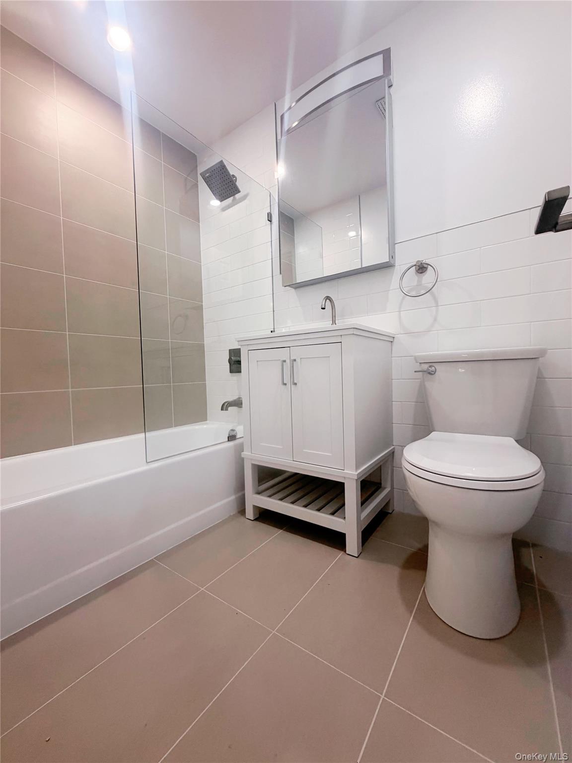 64-11 Springfield Boulevard, Unit B Queens, NY 11364 - Photo 7 of 11 a bathroom with a white toilet and a bathtub
