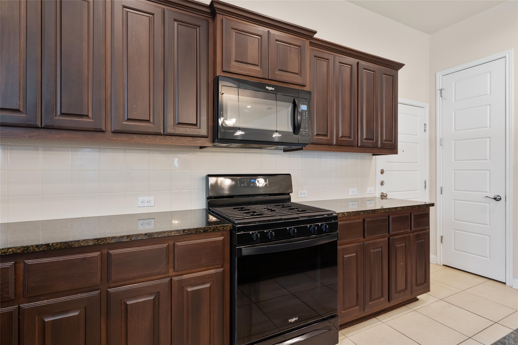 6907 Idea Road Austin, TX 78741 - Photo 9 of 36 a kitchen with granite countertop wooden cabinets and stainless steel appliances