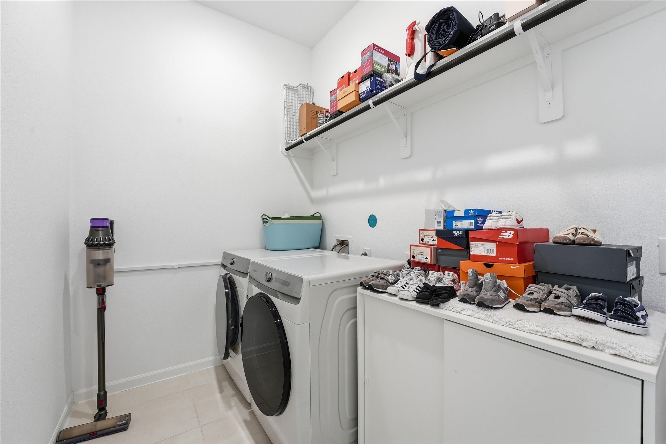 6071 Windward Falls Way Porter, TX 77365 - Photo 23 of 33 This photo shows a tidy laundry room with a washer and dryer and storage shelves.