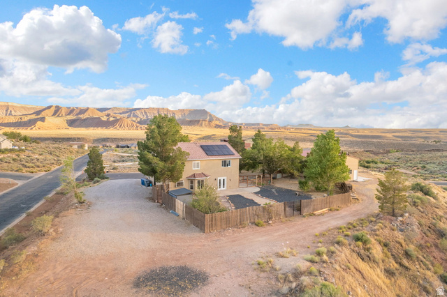 1440 West 100 South Virgin, UT 84779 - Photo 42 of 45 Two-story stucco residence featuring a fenced backyard, mature trees, and solar panels on the roof