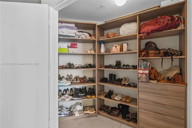a view of walk in closet with clothes and shoes