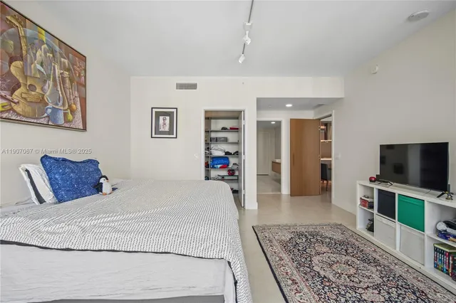 a bedroom with a large bed and a flat screen tv