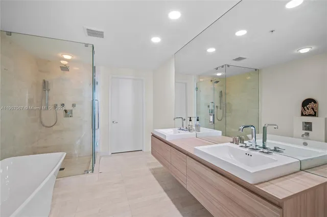 a bathroom with a double vanity sink mirror and shower