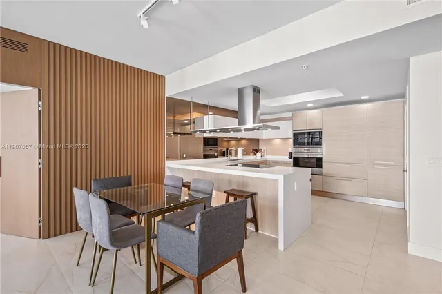 a kitchen with kitchen island a dining table and chairs