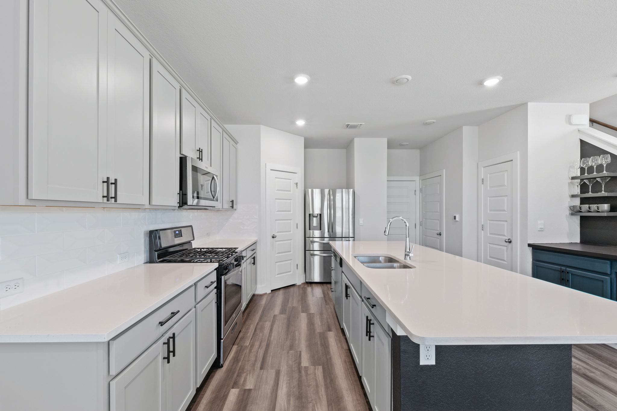 7312 Travertine Spring Drive Austin, TX 78744 - Photo 8 of 32 Culinary creations come to life in this kitchen, featuring stainless steel appliances and an expansive island.
