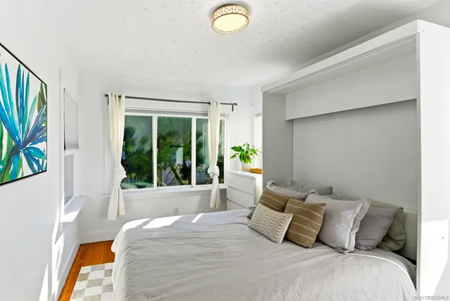 a bedroom with a bed and a large window