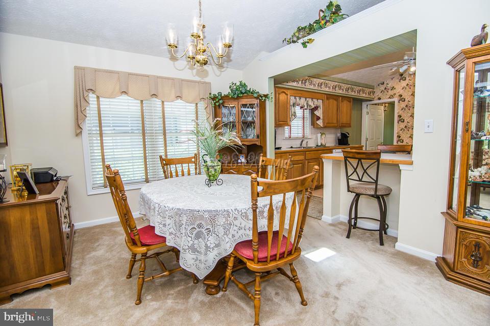 217 Windjammer Road Ocean Pines, MD 21811 - Photo 11 of 47 a view of a dining room with furniture a chandelier and wooden floor