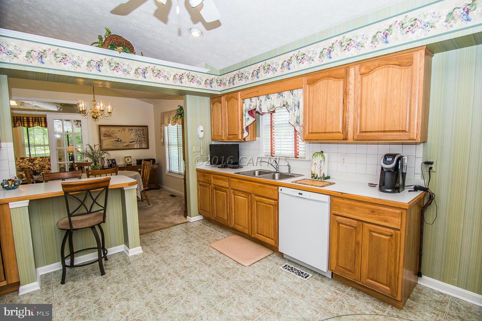 217 Windjammer Road Ocean Pines, MD 21811 - Photo 24 of 47 a kitchen with sink cabinets and dining table