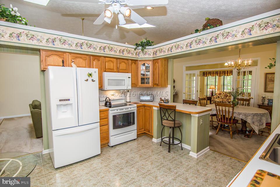 217 Windjammer Road Ocean Pines, MD 21811 - Photo 26 of 47 a kitchen with white cabinets and white appliances