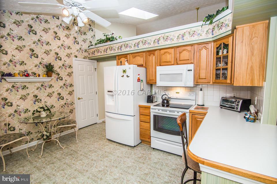 217 Windjammer Road Ocean Pines, MD 21811 - Photo 28 of 47 a kitchen with a refrigerator and white cabinets