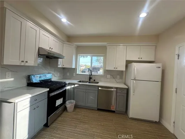 a kitchen with a sink a refrigerator and cabinets