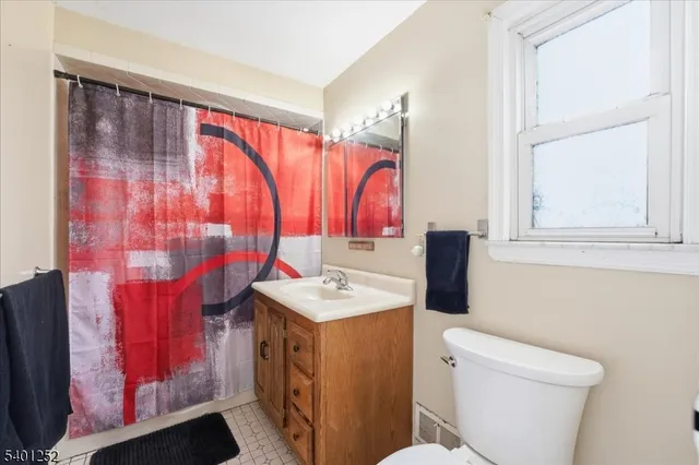 a bathroom with a sink toilet vanity and window