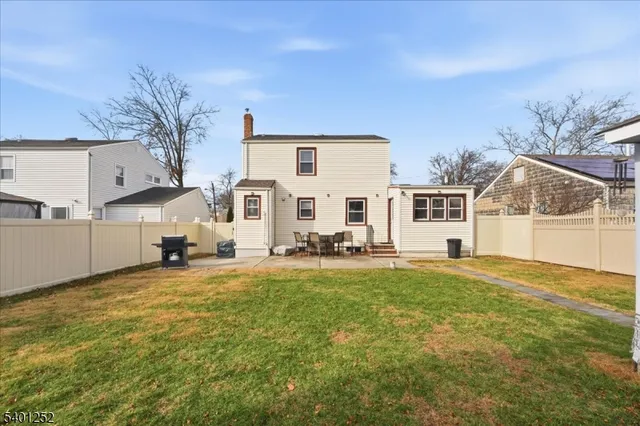 a view of a house with backyard and a tree
