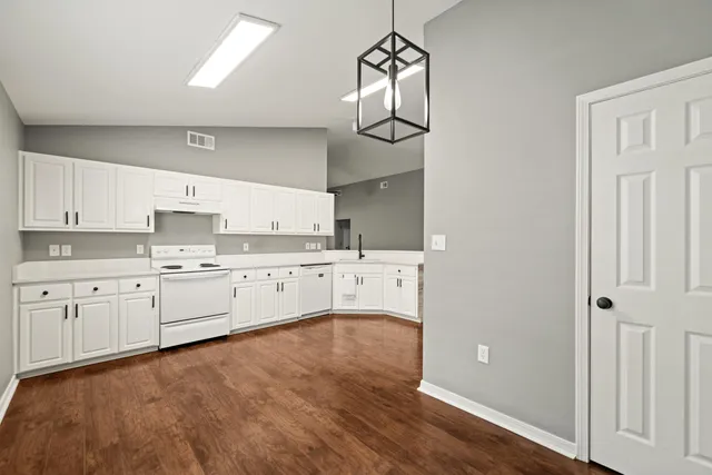 a large white kitchen with cabinets
