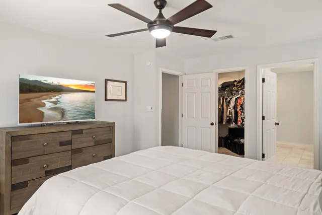 a bedroom with a bed and a mirror on the dresser