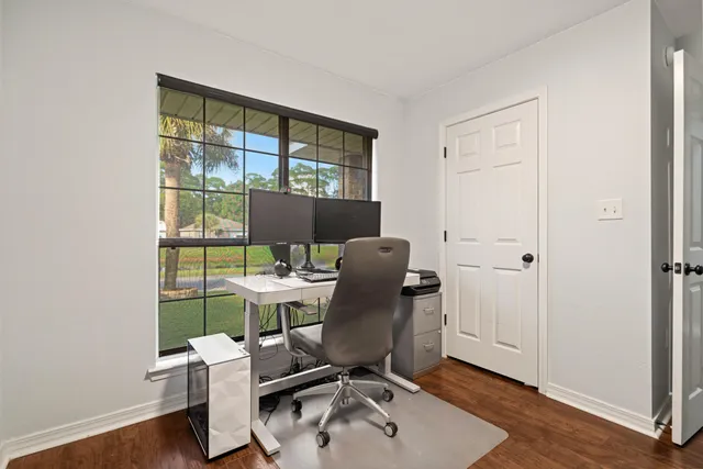 a view of a workspace with furniture and a window