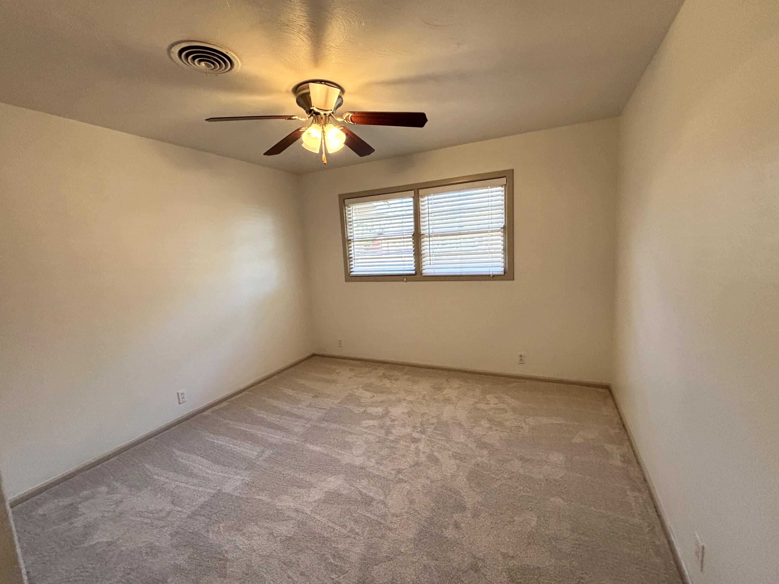 3415 58th Street Lubbock, TX 79413 - Photo 21 of 38 an empty room with a chandelier fan and windows