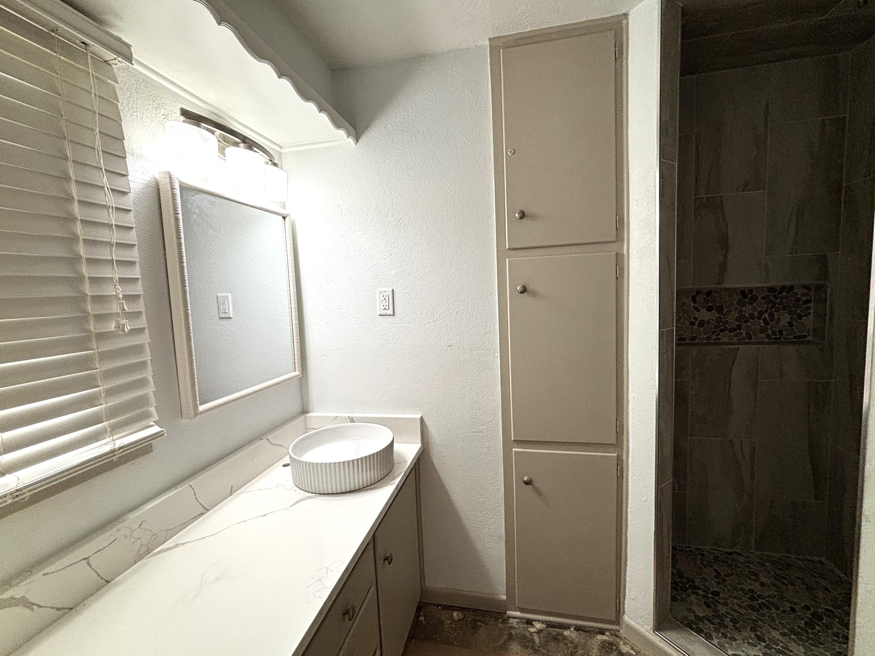 3415 58th Street Lubbock, TX 79413 - Photo 28 of 38 a bathroom with a sink and a mirror