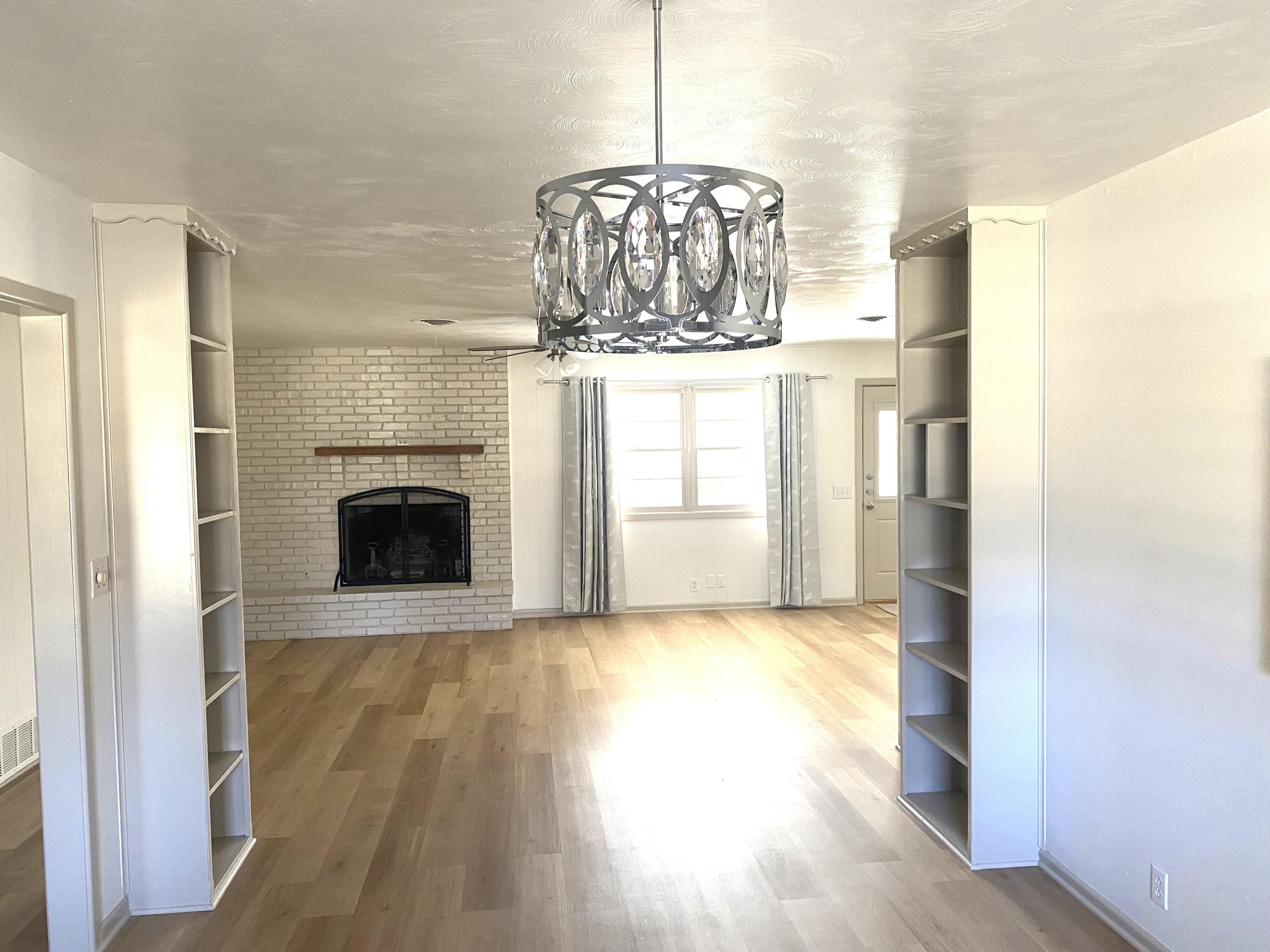 3415 58th Street Lubbock, TX 79413 - Photo 4 of 38 a view of empty room with wooden floor and fireplace
