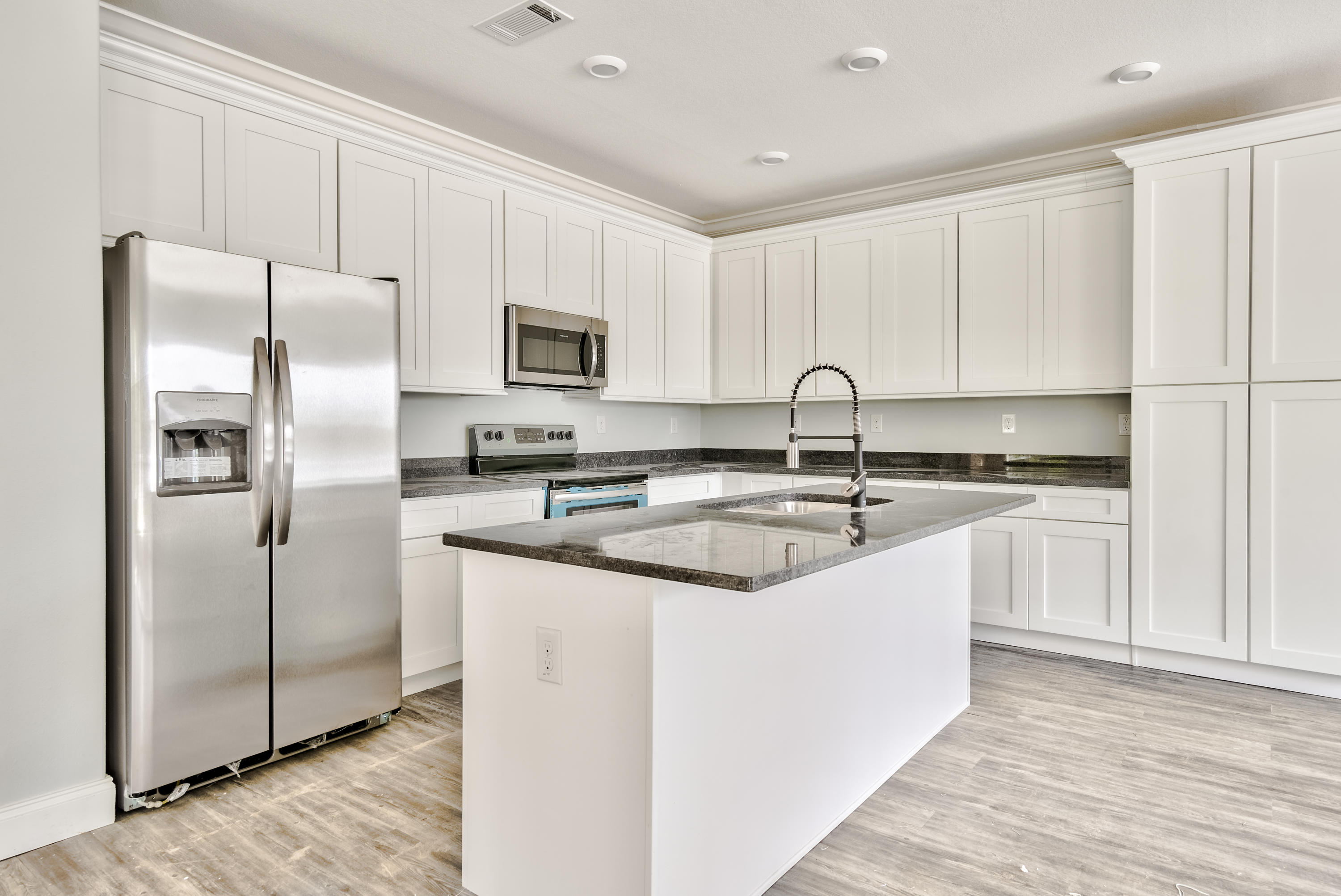 455 North County 395 Santa Rosa Beach, Unit 1 Santa Rosa Beach, FL 32459 - Photo 7 of 13 a kitchen with stainless steel appliances granite countertop a sink a refrigerator a stove a microwave and cabinets