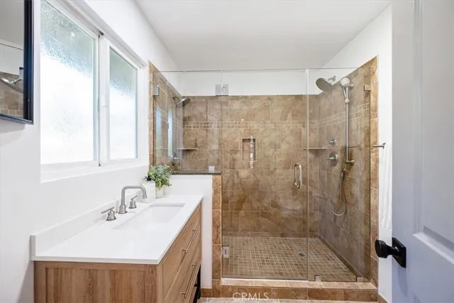 a bathroom with a sink a mirror and a shower