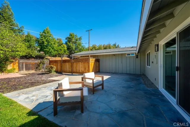 a view of a patio with table and chairs with wooden fence and plants