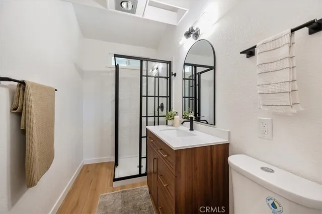 a bathroom with a sink a toilet a mirror and shower