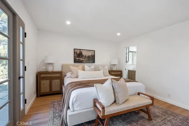a bedroom with a bed and wooden floor