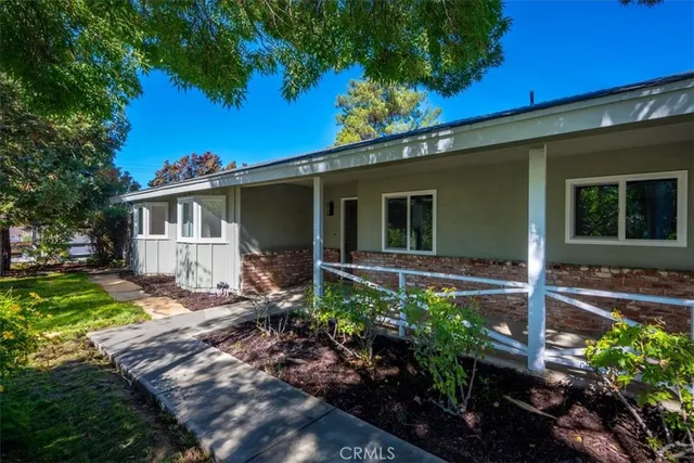 a view of a house with backyard and sitting area