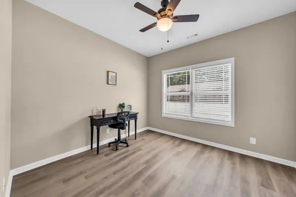 a workspace with wooden floor and a window