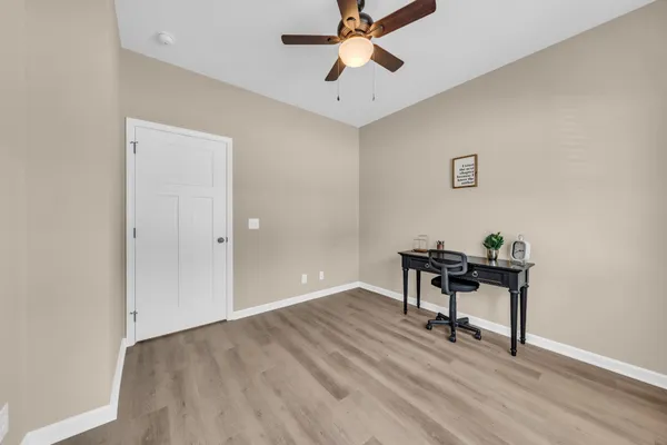 a view of room with a wooden floor and a ceiling fan