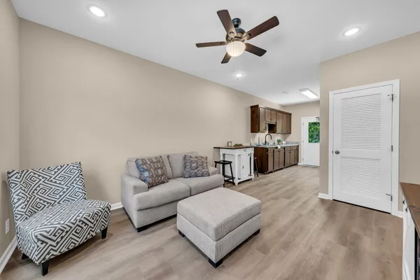 a living room with furniture and view of kitchen