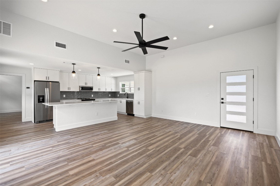 11151 Highway 71 Spicewood, TX 78669 - Photo 18 of 40 Unit B – Open-concept entry and kitchen showcasing a center island, white cabinetry, stainless steel appliances, and light countertops.