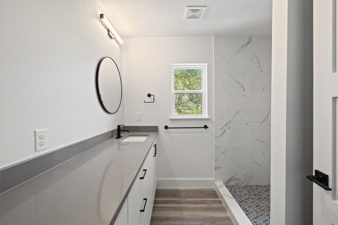 11151 Highway 71 Spicewood, TX 78669 - Photo 34 of 40 Unit C – Full bathroom showcasing gray quartz countertops and a luxurious walk-in shower.