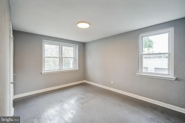 an empty room with windows and closet