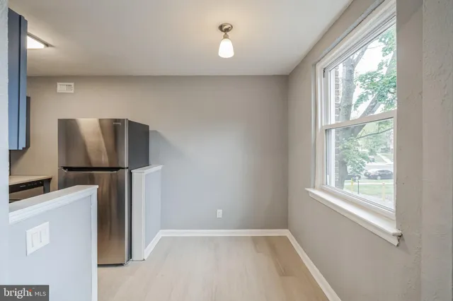 a view of a kitchen with a refrigerator cabinet and a window