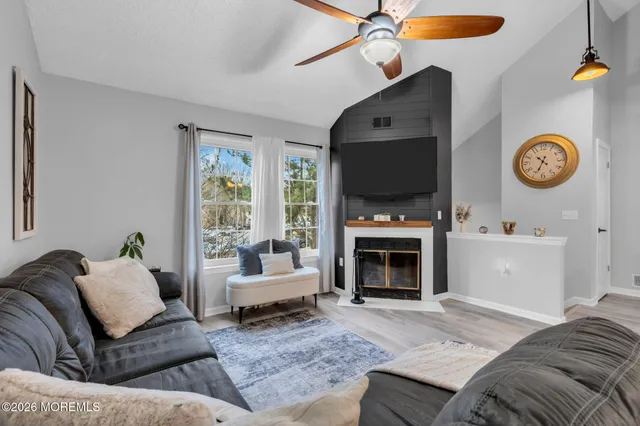 a living room with furniture a fireplace and a flat screen tv