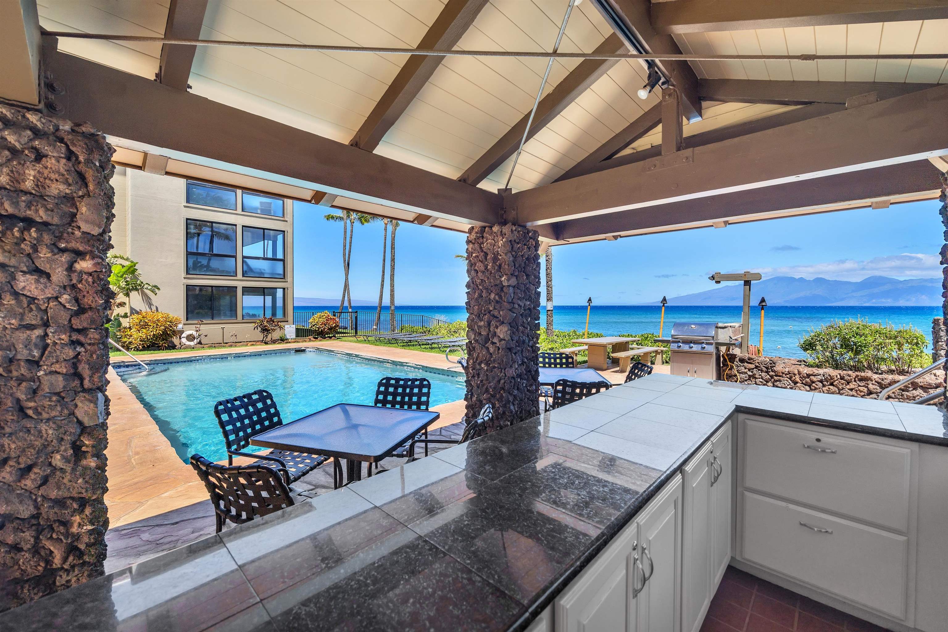 4095 Lower Honoapiilani Road, Unit 114B Lahaina, HI 96761 - Photo 11 of 18 a view of a swimming pool with a lounge chairs in patio