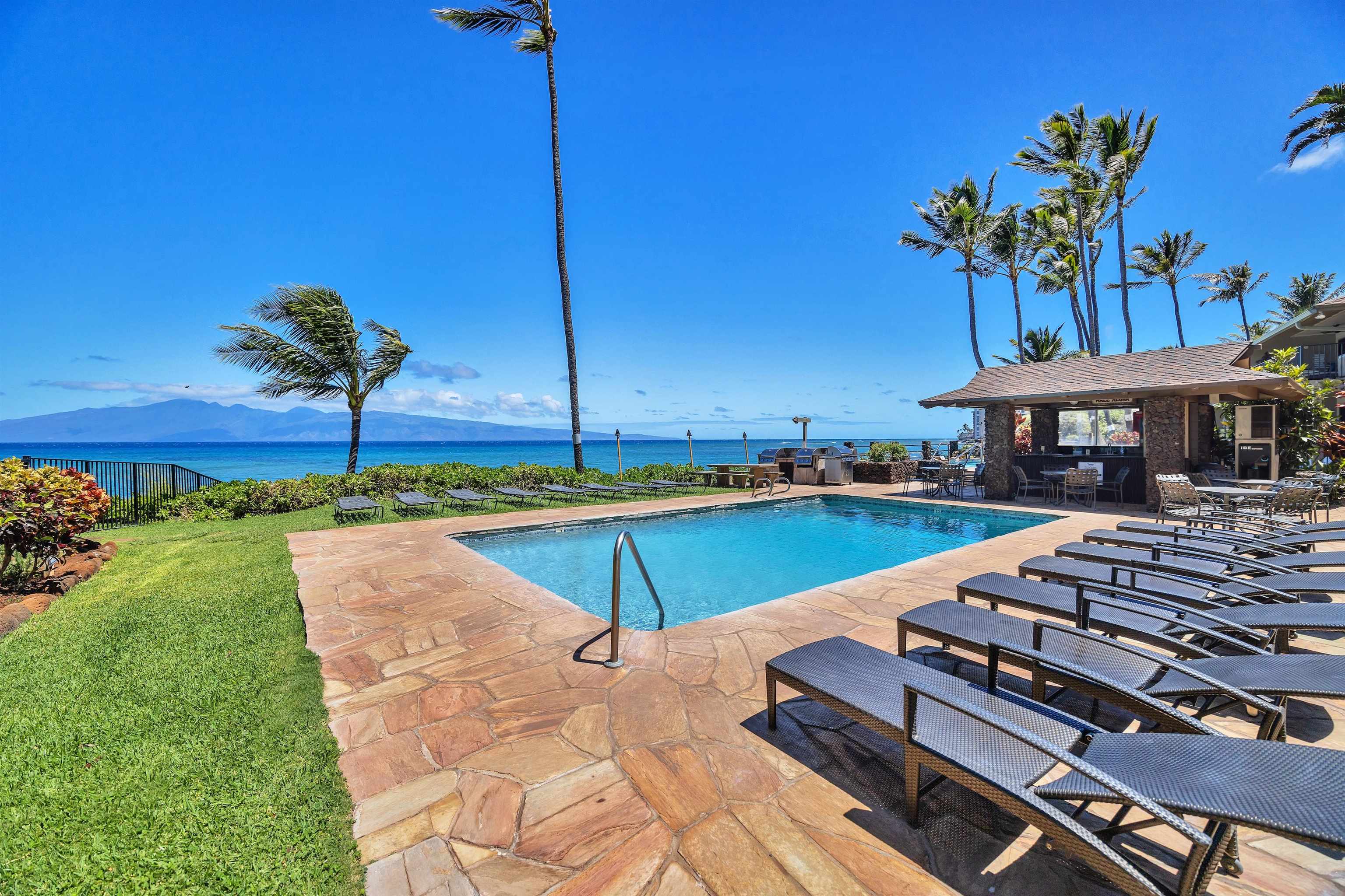 4095 Lower Honoapiilani Road, Unit 114B Lahaina, HI 96761 - Photo 15 of 18 a view of a swimming pool with a lounge chairs