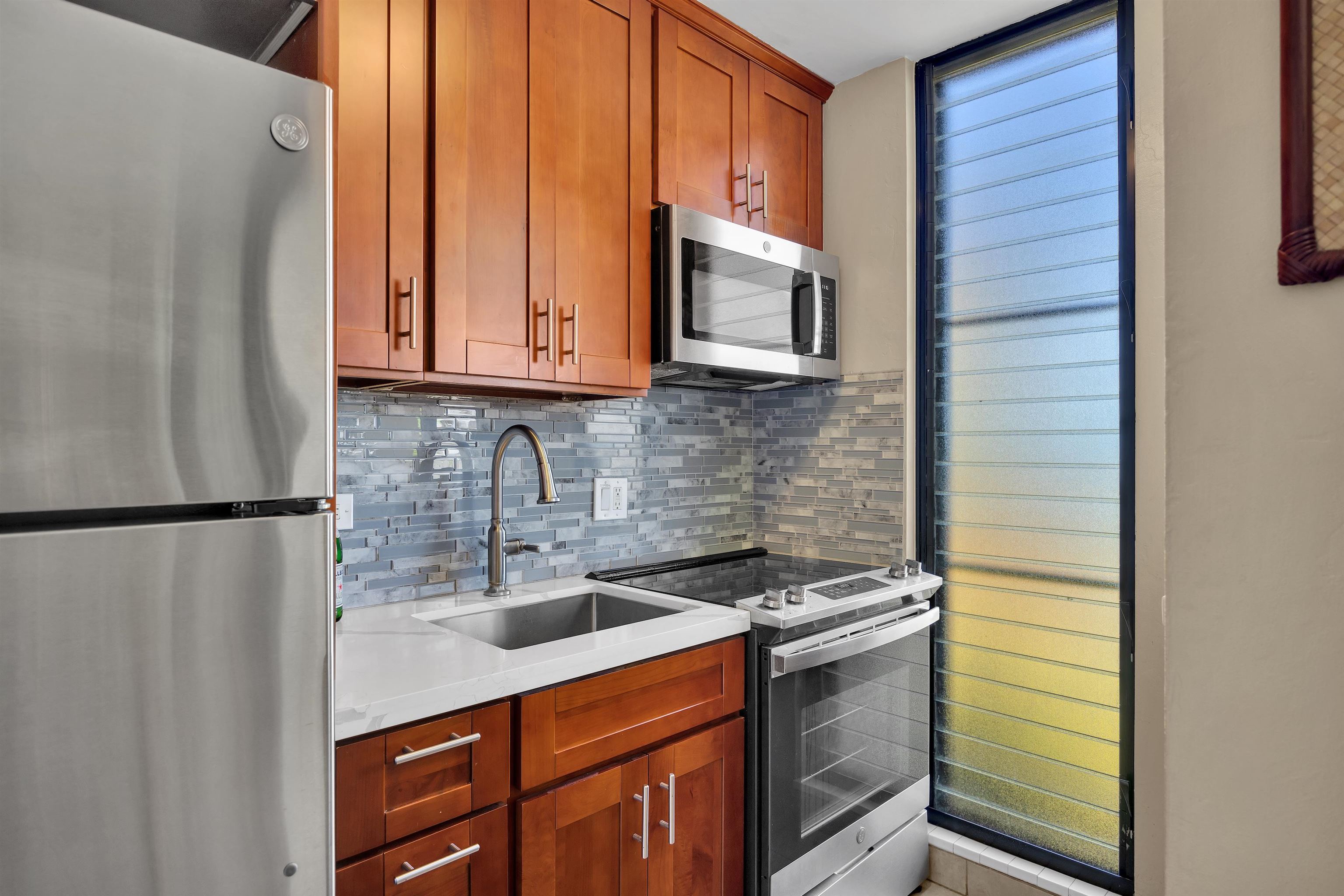 4095 Lower Honoapiilani Road, Unit 114B Lahaina, HI 96761 - Photo 5 of 18 a kitchen with a sink and a refrigerator