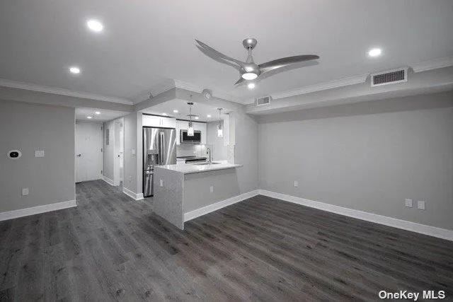 a view of a kitchen with a sink dishwasher a refrigerator and wooden floor